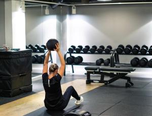 a woman sitting on the floor in a gym at Comfort Hotel Børsparken in Oslo