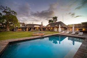 une grande piscine en face d'une maison dans l'établissement Kamagu Safari Lodge, à Touwsrivier