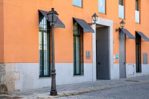 uma luz de rua em frente a um edifício laranja em Hotel AR Isabel de Farnesio em La Granja de San Ildefonso