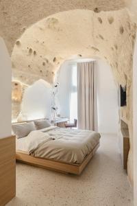 a bedroom with a large bed in a stone wall at La Dimora Di Metello in Matera