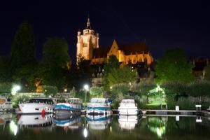 eine Gruppe von Booten im Wasser vor einem Gebäude in der Unterkunft Duplex charmant idéalement situé in Dole