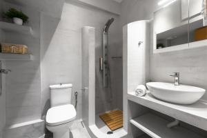 a white bathroom with a toilet and a sink at Melba's Residence Polihrono by Luxlikehome in Polychrono +19 photos