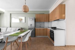 a kitchen and dining room with a table and chairs at Melba's Residence Polihrono by Luxlikehome in Polychrono