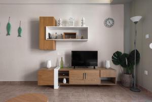 a living room with a television on a wooden cabinet at Melba's Residence Polihrono by Luxlikehome in Polychrono