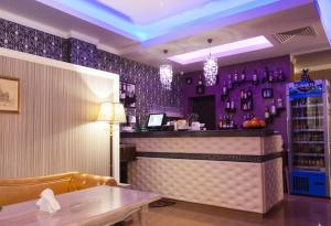 a bar in a restaurant with purple walls and a table at Hotel Verona in Byala Ruse +34 photos