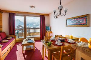 a living room with a table and a dining room at travelski home select - Résidence L'Ecrin des Sybelles in La Toussuire