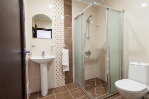 a bathroom with a shower and a toilet and a sink at Hotel Verona in Byala Ruse
