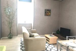 ein Wohnzimmer mit Couch und Fernseher in der Unterkunft Les Plos, gîte cosy in Le Vigan