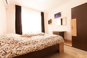 a bedroom with a bed and a large window at Hotel Verona in Byala Ruse