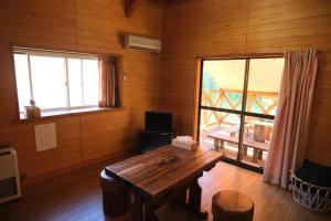Cette chambre en bois dispose d'une table en bois et d'une fenêtre. dans l'établissement フォレストコテージ奥州, à Oshu