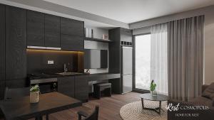 a kitchen and living room with black cabinets and a table at iRest COSMOPOLIS Vinh Yen in Yen