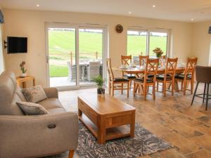 a living room with a couch and a table and chairs at Holly Lodge in Welshpool