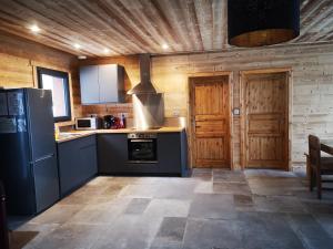 cocina con electrodomésticos azules y paredes de madera en Chalet à L'Orée du Bois en Le Tholy