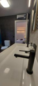 ein weißes Bad mit einem Waschbecken und einem WC in der Unterkunft Hotel La Cascada in Bredene