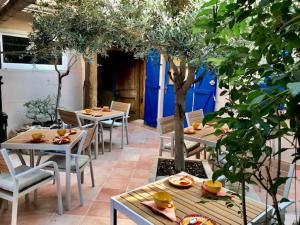 a patio with tables and chairs and trees at Hôtel Le Colbert in Avignon