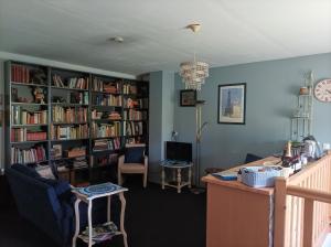 a living room with book shelves filled with books at B&B Fromenteau in Ternant