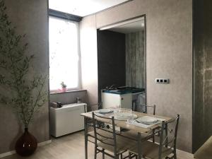 a dining room with a table and chairs and a kitchen at Les Plos, gîte cosy in Le Vigan