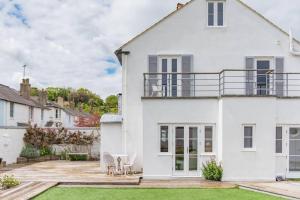 a white house with a patio and a yard at Trafalgar Cottage - Stunning sea view property on beach in Kingsdown