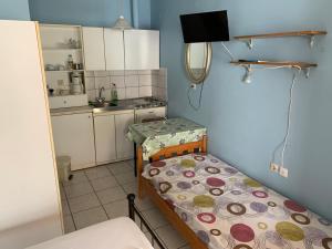 a small room with a bed and a kitchen at Alexandras Appartments in Igoumenitsa