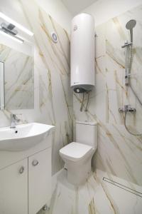 a bathroom with a toilet and a sink and a mirror at Апартамент BOHO CHIC Free parking in Varna City +28 photos