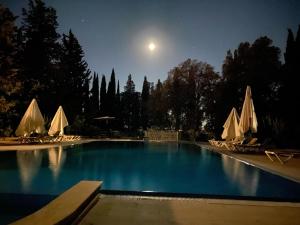 a large swimming pool at night with a full moon at Relais Villa Sant'Isidoro in Colbuccaro