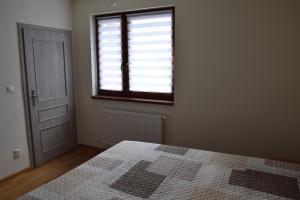 ein leeres Zimmer mit einem Bett und einem Fenster in der Unterkunft Mýto apartments in Mýto pod Ďumbierom