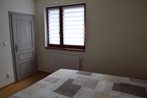 an empty room with a bed and a window at Mýto apartments in Mýto pod Ďumbierom