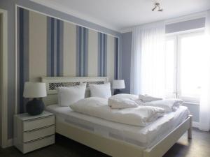 a bedroom with a large bed with white sheets and pillows at 3-Raum-Appartements in der Rabenstraße in Binz