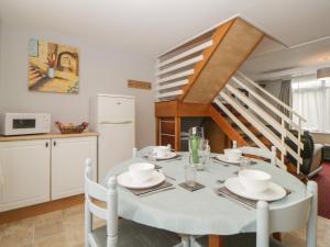 eine Küche und ein Esszimmer mit einem weißen Tisch und Stühlen in der Unterkunft Turtle Chalet in Dawlish