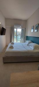 a bedroom with a large bed and a window at The Convo Athens Riviera in Athens