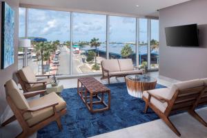 a living room with chairs and a view of the ocean at Hyatt Place Aruba Airport in Oranjestad
