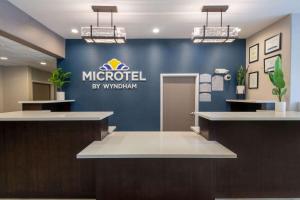 um átrio com um sinal microsoft numa parede azul em Microtel Inn & Suites by Wyndham Tracy em Tracy