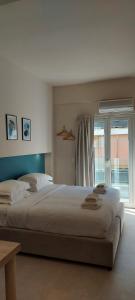 sypialnia z dużym łóżkiem i oknem w obiekcie The Convo Athens Riviera w Atenach