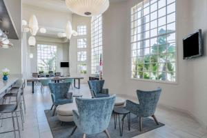 a dining room with chairs and a table and a tv at Wyndham Garden San Diego in San Diego