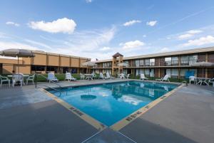 un hôtel avec une piscine en face d'un bâtiment dans l'établissement Super 8 by Wyndham Goldsboro, à Goldsboro