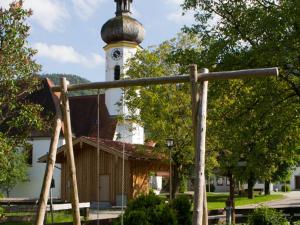 uma luz de rua em frente a um edifício com uma torre de relógio em König Andrea Schwaigerhof Rottau em Rottau