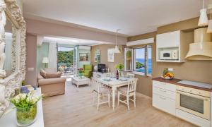 a kitchen and living room with a table and chairs at Villa Boban Deluxe in Dubrovnik