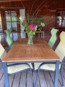 a wooden table with a vase of flowers on it at Mijn Chalet in Erm