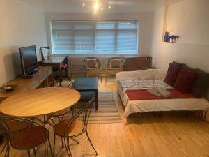 een kamer met 2 bedden en een tafel en stoelen bij Cozy 1 Bedroom Basement Flat in Londen