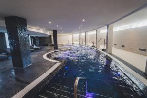 
a large swimming pool in a large room at Gara Suites Golf & Spa in Playa de las Americas
