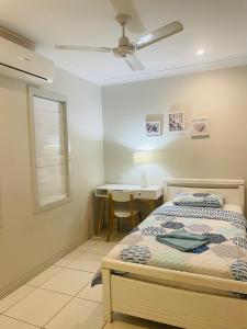 a bedroom with a bed and a desk and a window at Martyn st house in Cairns