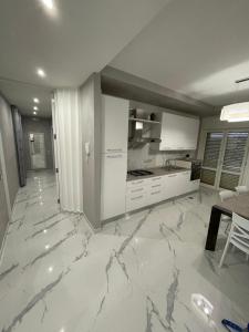 a kitchen with white cabinets and a marble floor at B&B IL PICCOLO PRINCIPE in Mercato San Severino