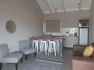 a kitchen with a bar with stools and a refrigerator at Goedehoop Game Farm in Bloemfontein