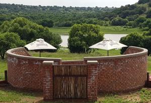 dos sombrillas sentadas en la parte superior de una pared de ladrillo en Goedehoop Game Farm en Bloemfontein