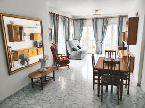 a living room with a table and chairs and a mirror at Marina Sunrise Puerto in Torrevieja