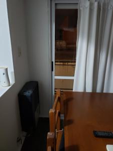 um quarto com uma mesa de madeira e uma televisão em Don Roque II em Santa Rosa