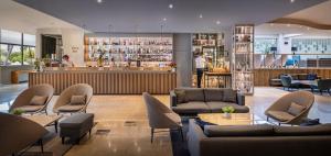 a lobby with couches and a bar in a building at Valamar Diamant Hotel in Poreč