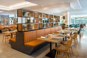 a restaurant with wooden tables and chairs and books at Valamar Diamant Hotel in Poreč +31 photos