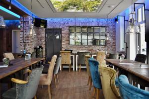 a restaurant with wooden tables and chairs and a brick wall at Weyotel in Weyhe