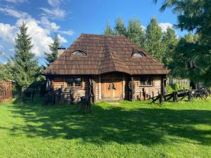 una vecchia casa in legno con tetto su un campo di Gród Pędzików a Chęciny